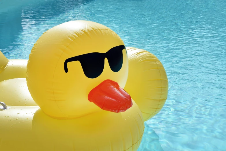 a rubber duck with sunglasses floating in a pool