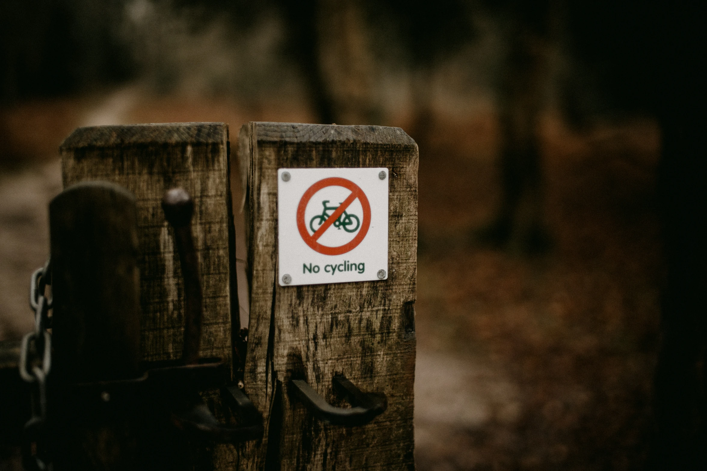 a wooden post with a sign that reads no bicycles on it