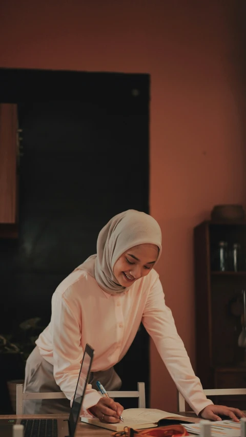 a woman wearing hijab sitting at a table