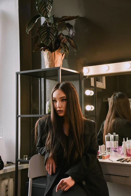 a woman sitting down while she has her hair done