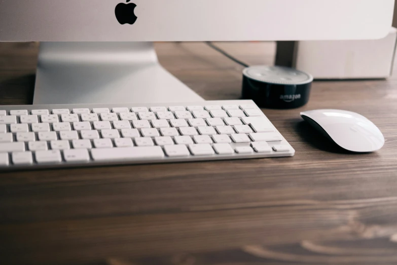 a white apple computer on a wooden desk