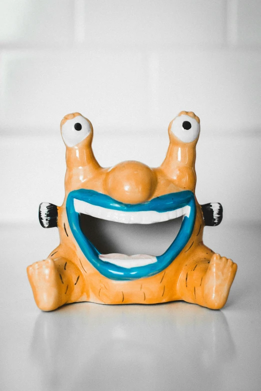 a ceramic object with eyes and smiling head