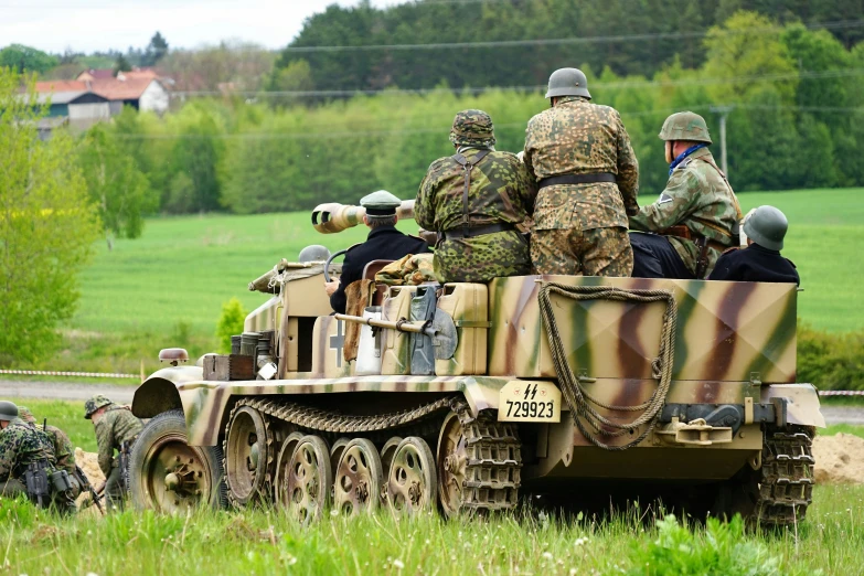 some soldiers and some vehicles in the grass