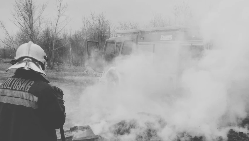 a black and white po of someone watching a bus burn