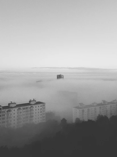 a city is in the fog near the top of a hill