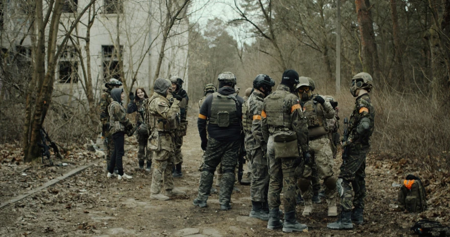 several soldiers looking at soing while standing outside