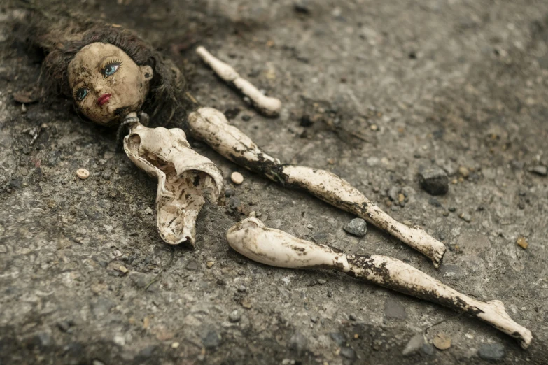 a bone doll with blue eyes on concrete