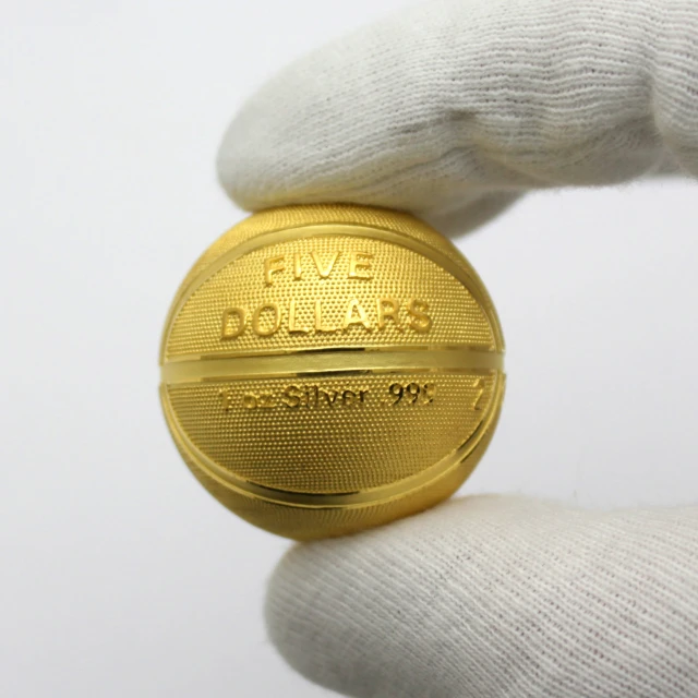 a close up of a person holding a gold colored basketball