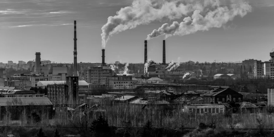 a view of an industrial city with smoke stacks rising from the factories