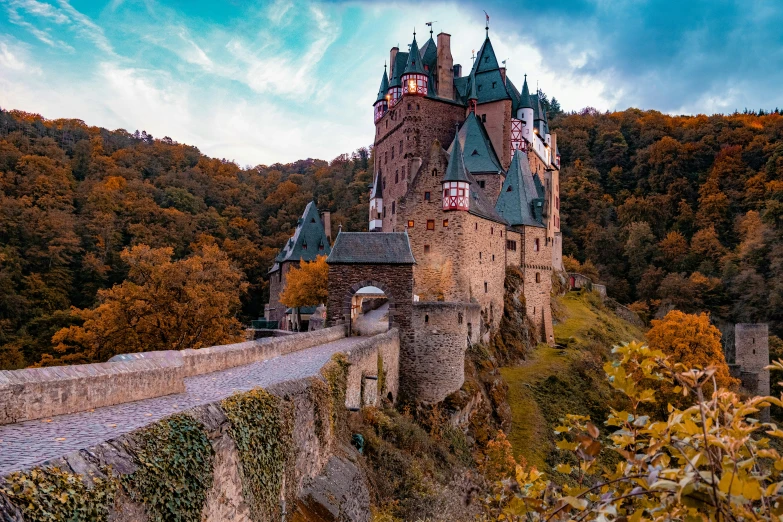 a castle near the water with trees on both sides