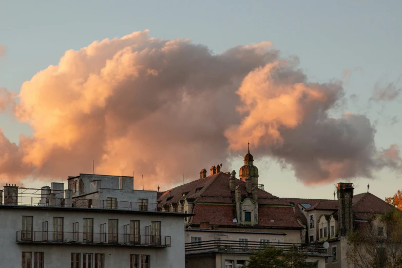 buildings in the foreground with large clouds looming