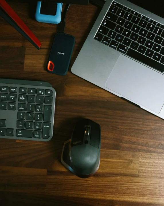 a couple of black computer keyboards on top of a wooden desk