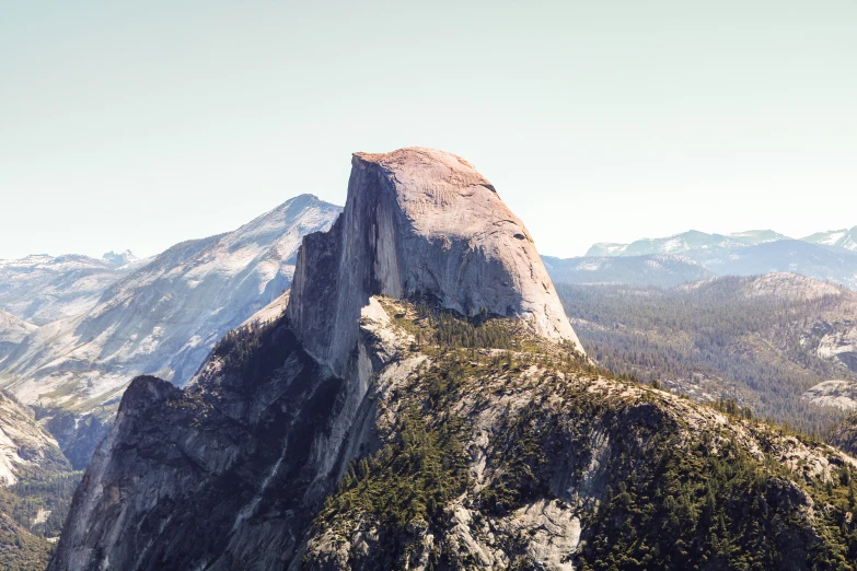 a rock outcropping on top of a mountain in the middle of mountains