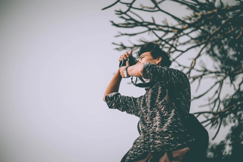 a young woman is taking a picture while holding a camera