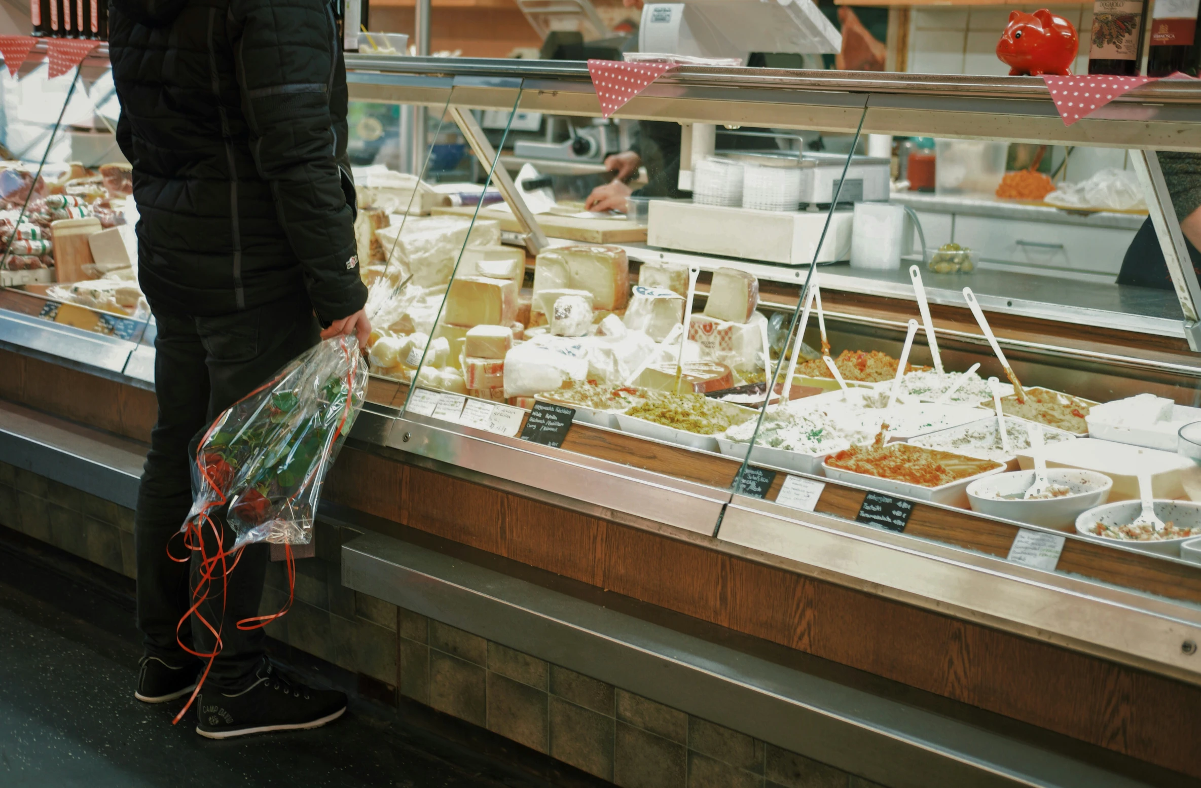 person holding grocery bag in front of store window