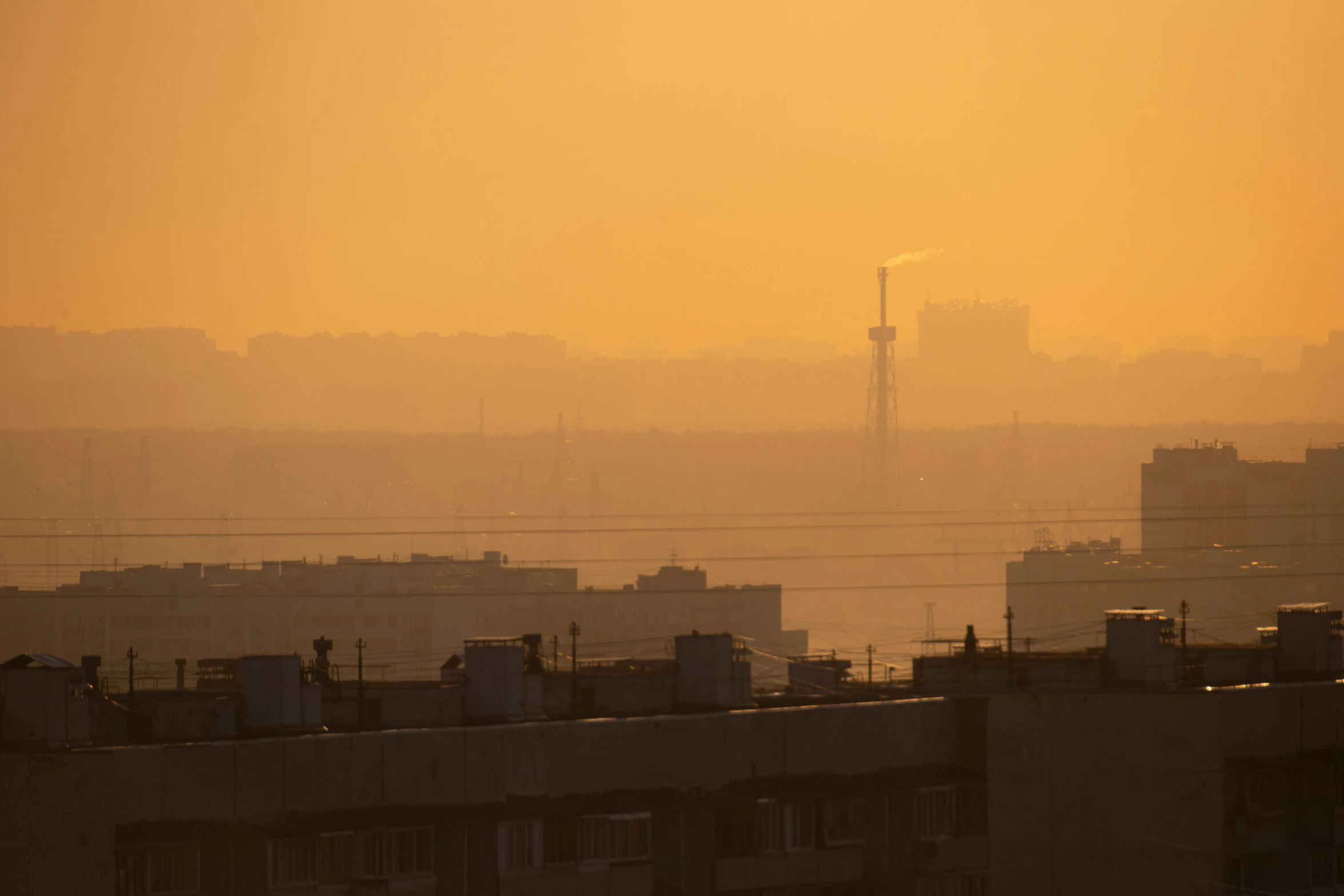 a hazy skyline is seen with buildings in the foreground