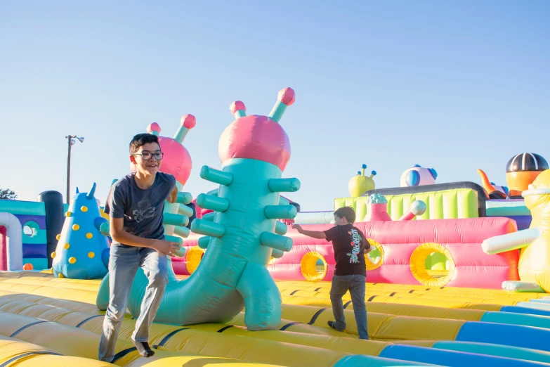 two men stand on large inflated toys in a city park