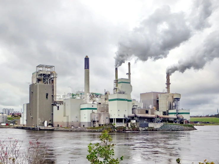 smoke billows from the stacks of the smoke stacks behind a factory