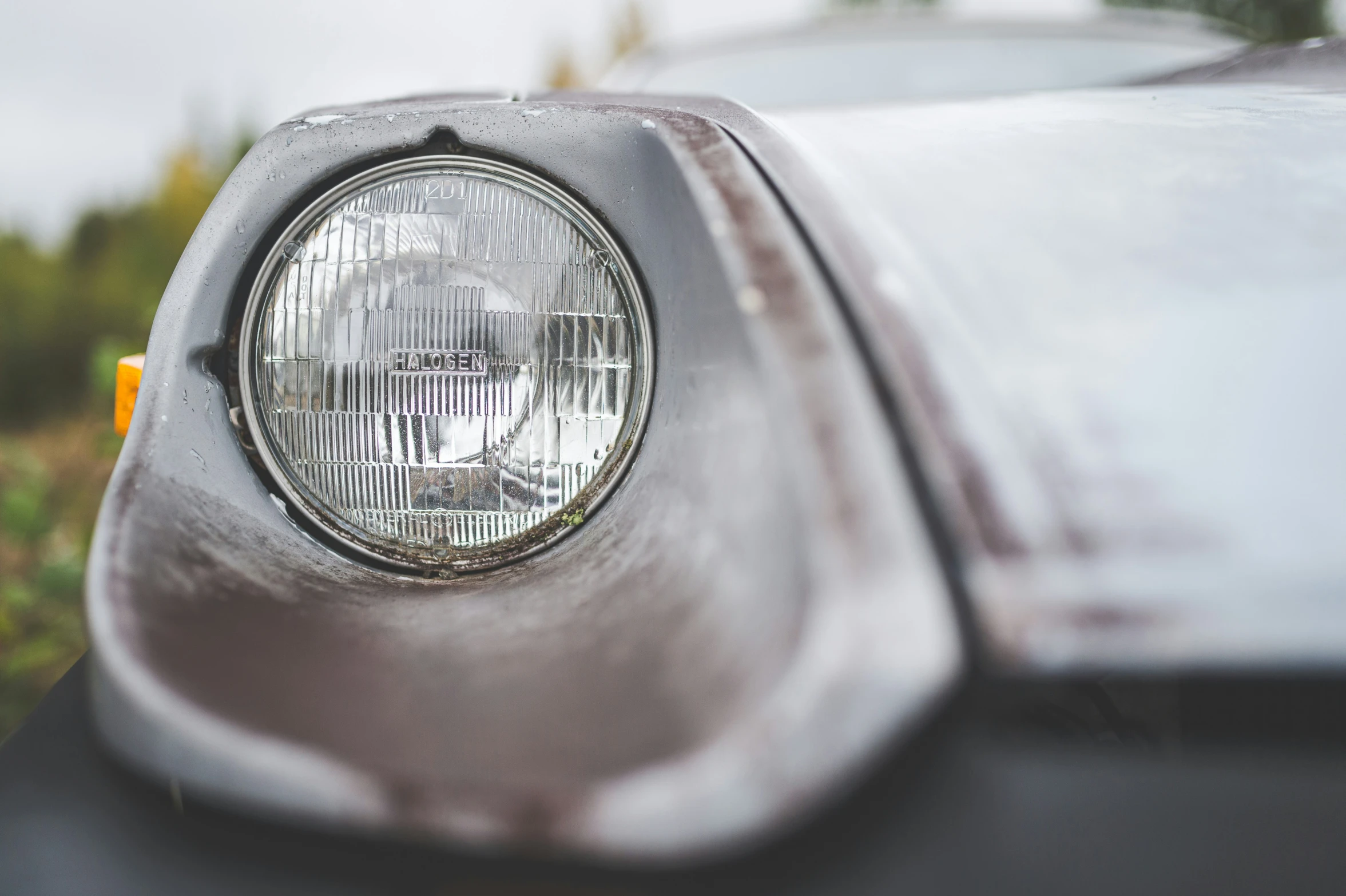 the front light of an old car on a road