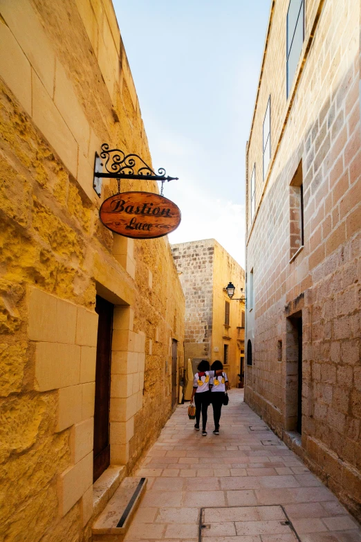 some people with umbrellas are walking down an alley