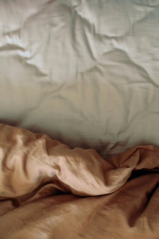 a brown comforter covers a bed with a pillow