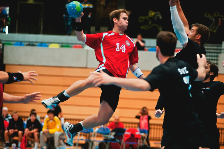 a boy jumps up for a ball as other men stand nearby