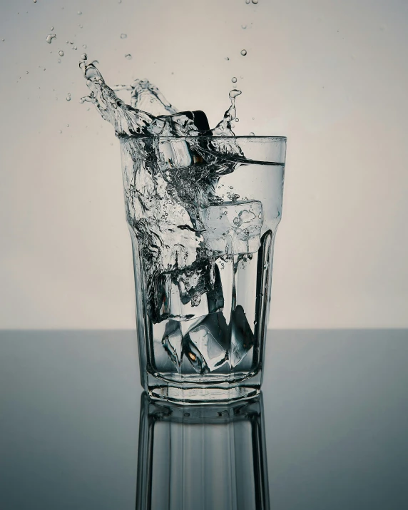 water is hitting into a glass on the table