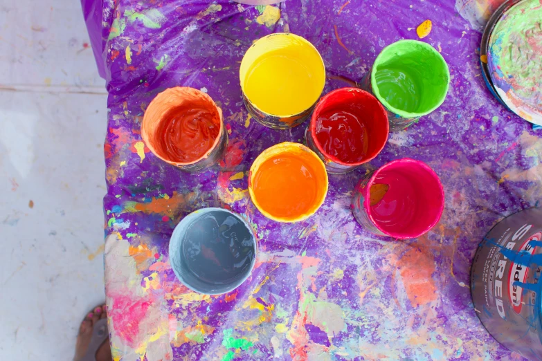 paint is on a table, next to several empty cup lids