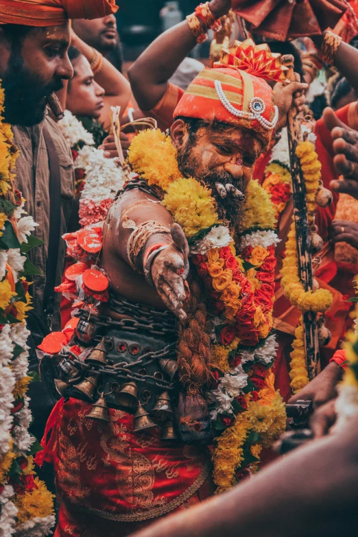 several people in elaborate costume and flowers at a festival