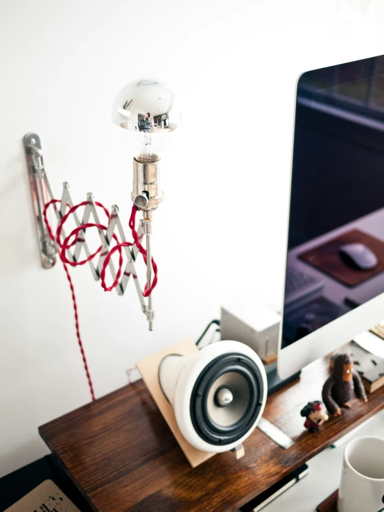 a wooden desk topped with a computer monitor and speakers