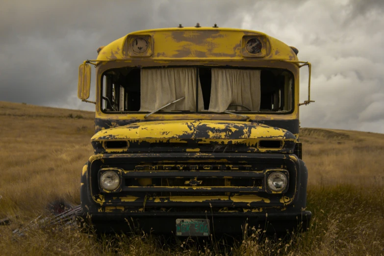 an old yellow and black school bus in a grass field