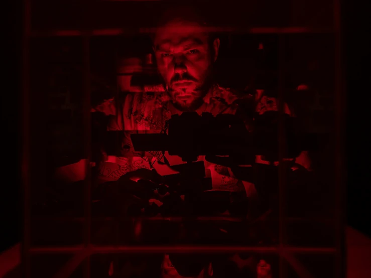 a red - lit po of a person behind bars on television