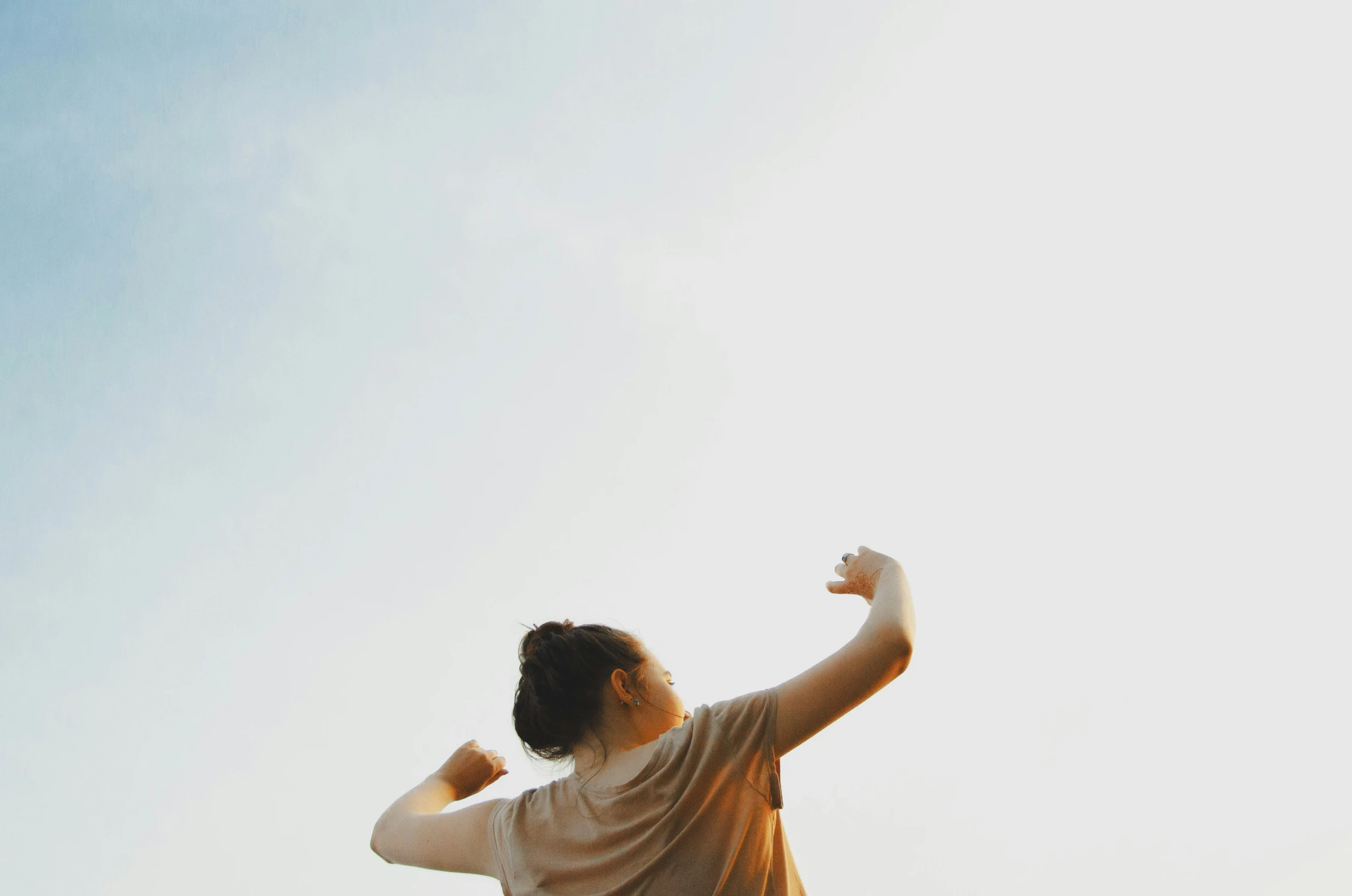 a young person stands holding a frisbee in the sky