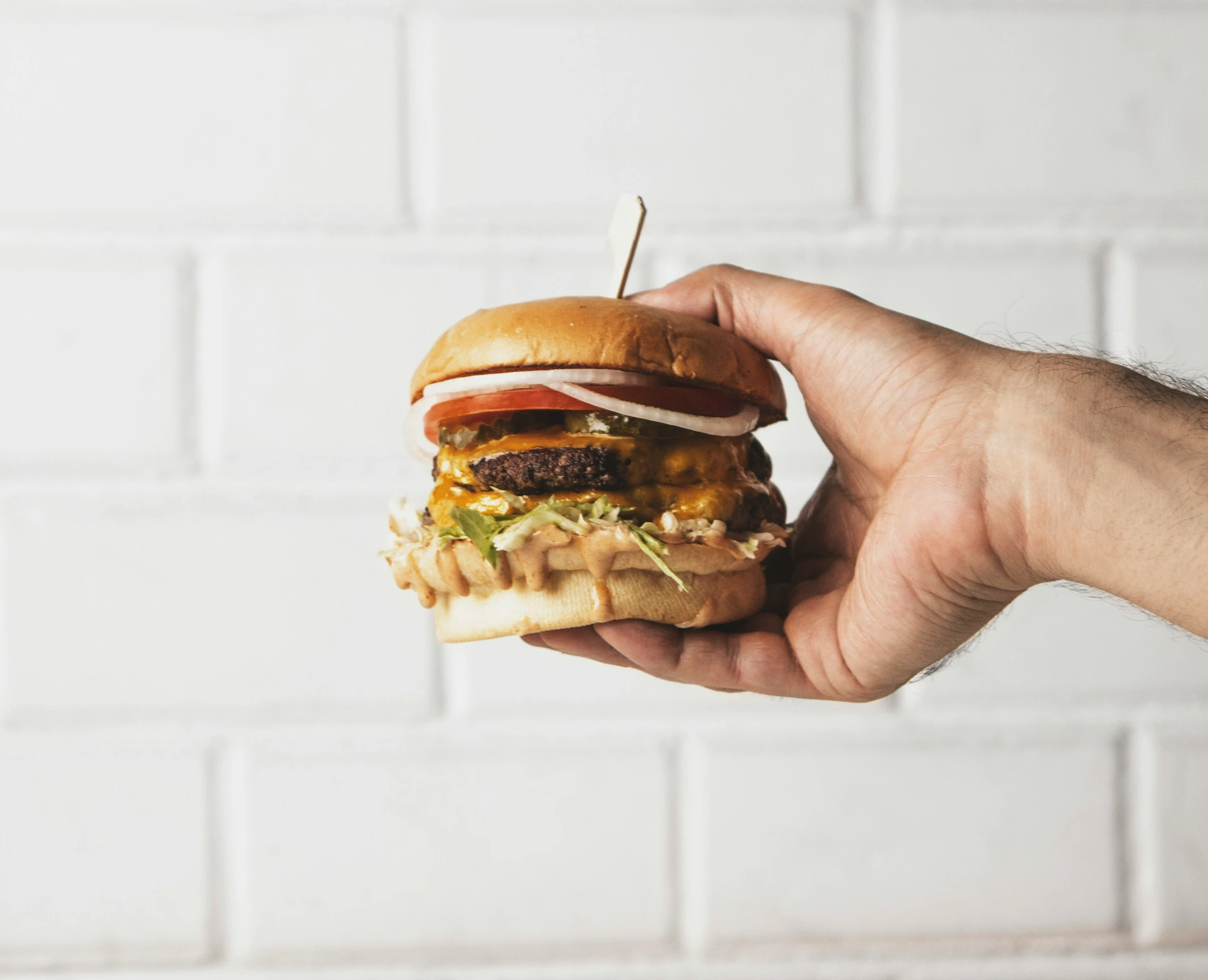 the person is holding the hamburger up to their face