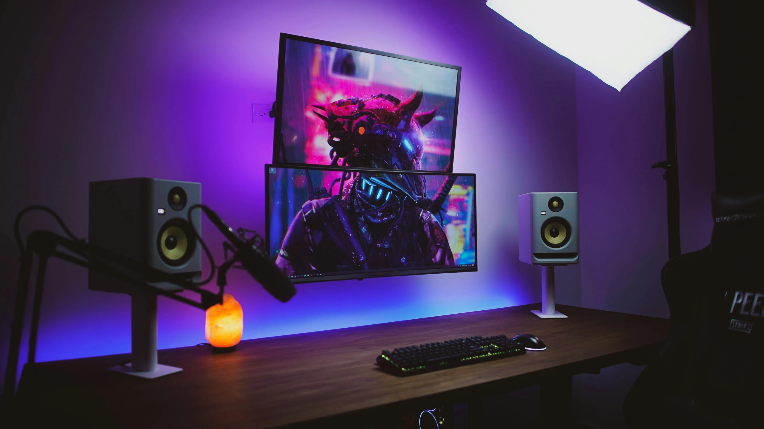 a computer monitor sits next to speakers on a wooden table