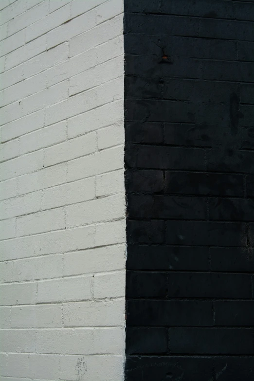 a white and black brick wall next to a street light