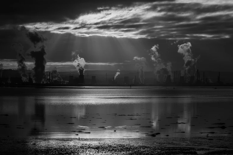 smoke from factories rising into the sky and a lake