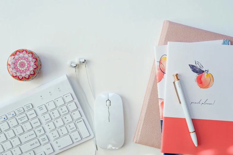 notebook on top of a computer keyboard, mouse and various accessories