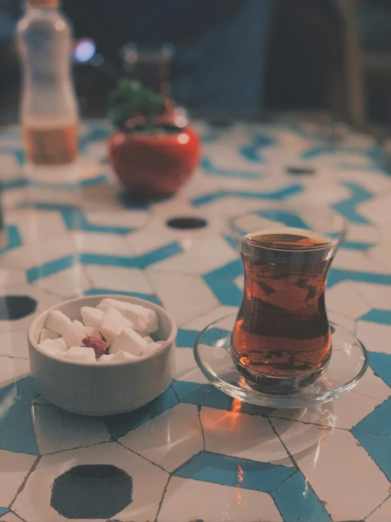 a table that has two bowls with food and a cup on it