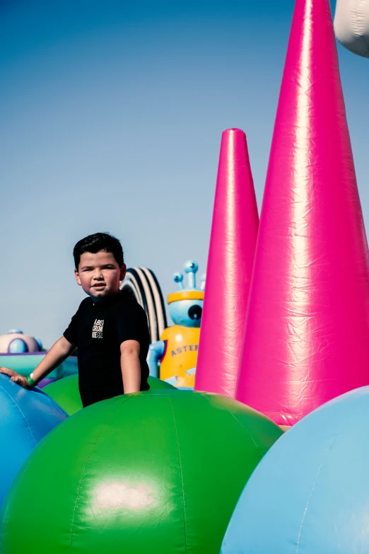 a boy plays inside a bunch of colorful bouncy balls