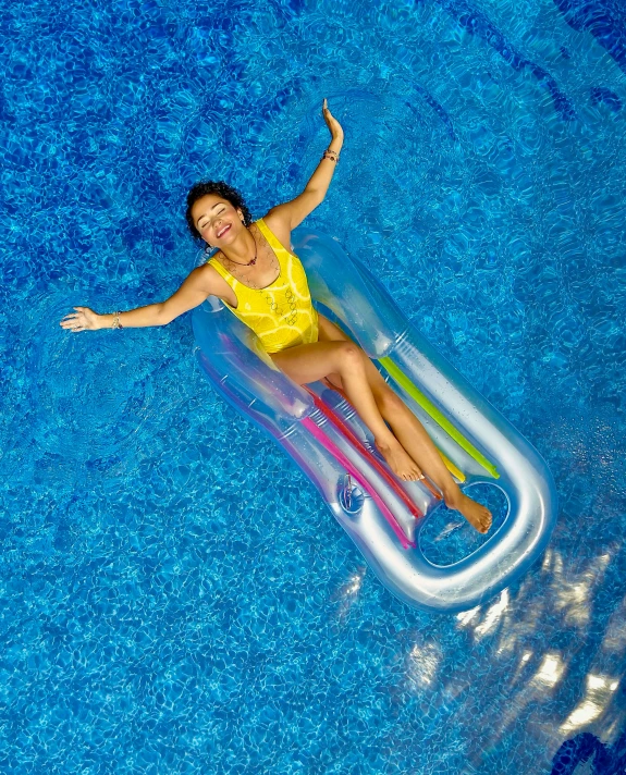 a woman laying on an inflatable raft in a pool