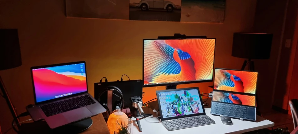 four computers sitting on top of a desk