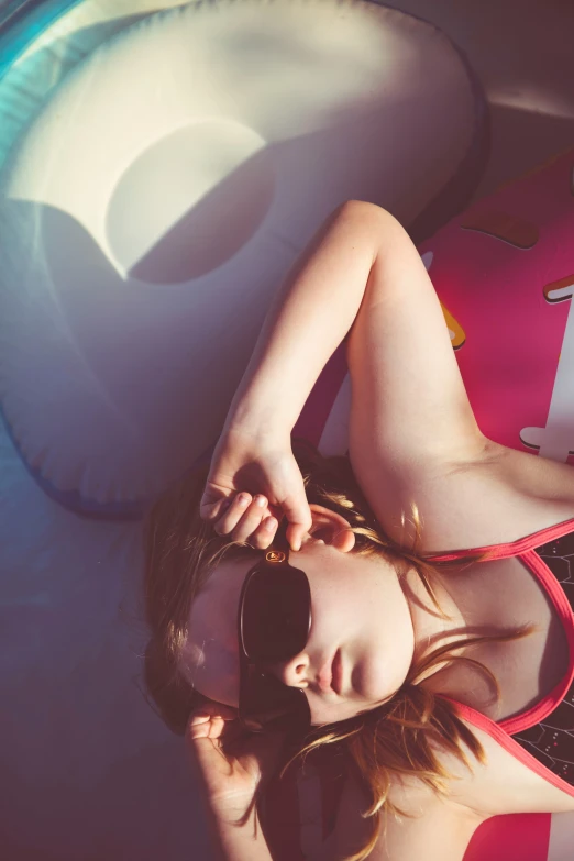 a woman in a bikini laying down on a beach towel