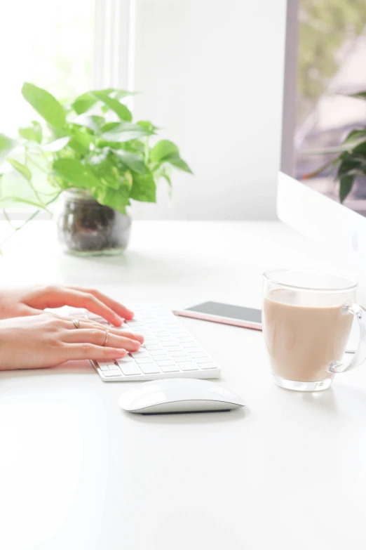 a table with a cup, drink and laptop