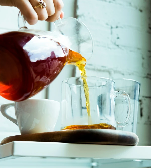 someone is pouring orange juice into a cup