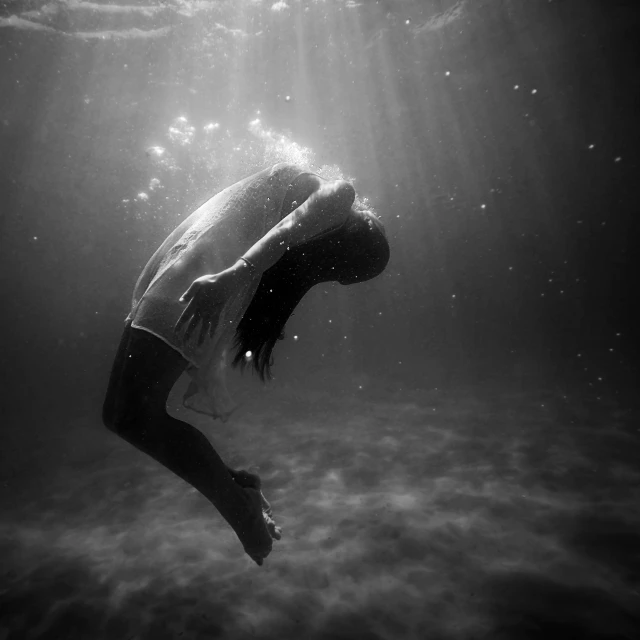 a girl under water in the middle of a body of water