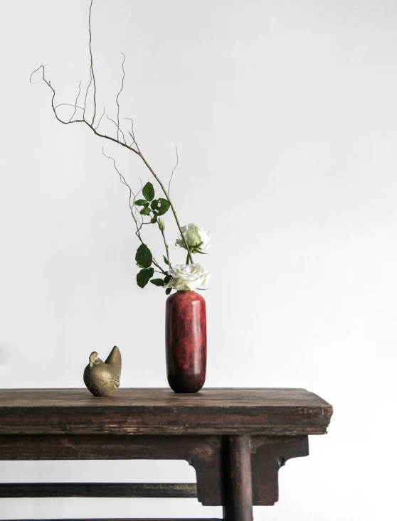 a vase with flowers on top of a wooden table