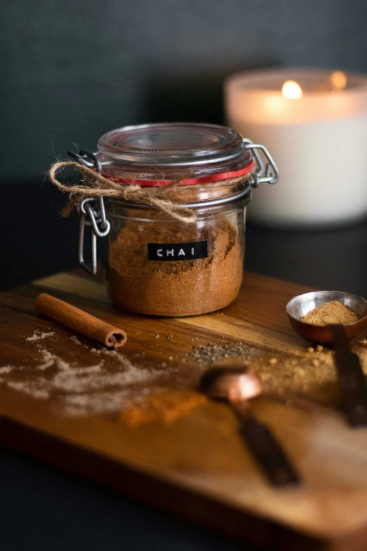 an old fashioned spice sits on a  board next to a candle