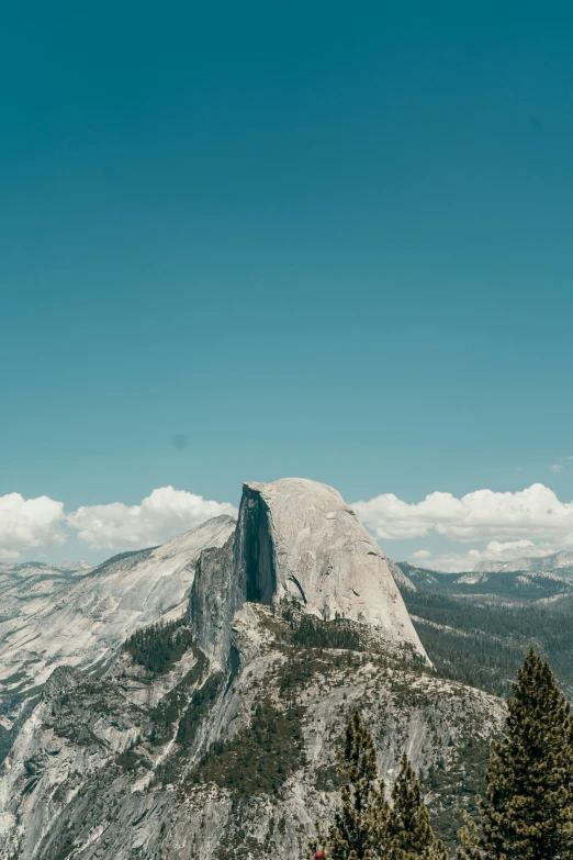 the mountain has large rocks on it with some trees growing around