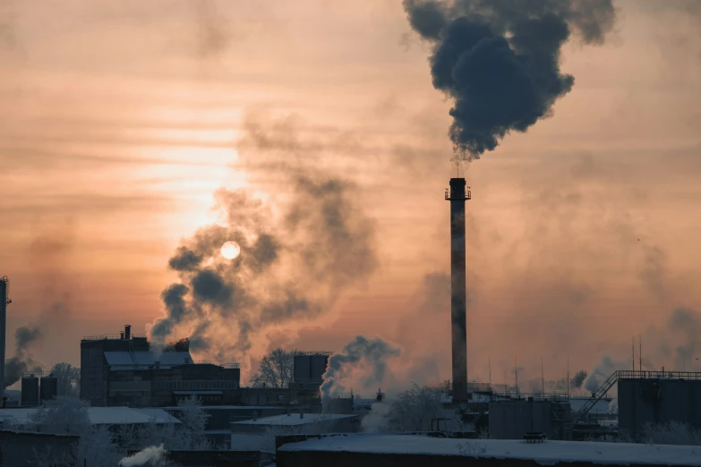 smoke comes from the pipes of a factory in winter